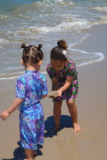 Two girls wearing Mystic Reef and Midnight Bloom UPF 50+ rashie sets playing at the beach